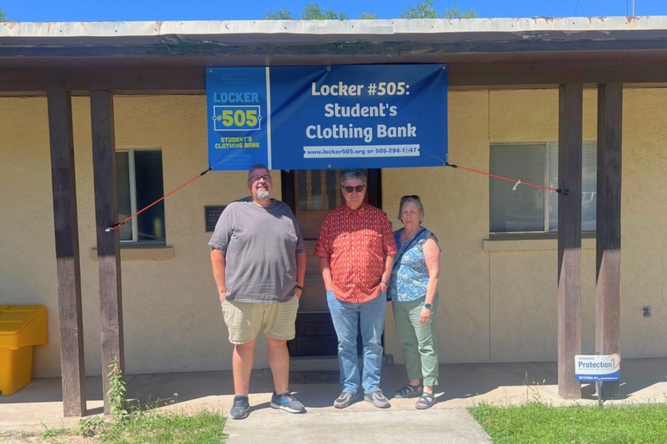 Three people standing outside a building