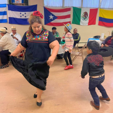 Adult woman and young boy dancing a traditional dance from a Hispanic country