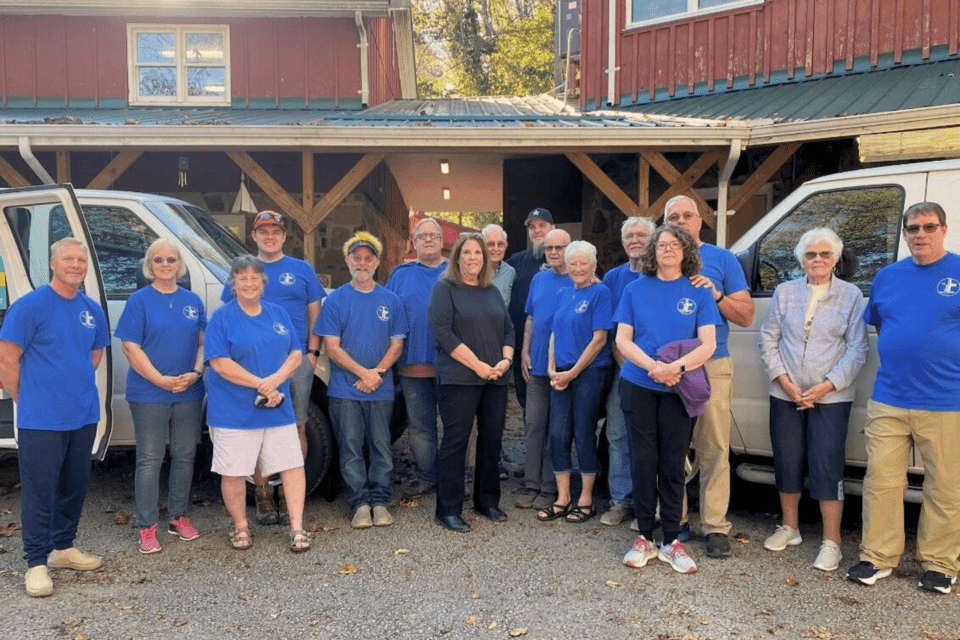 Church volunteers standing next to cargo vans