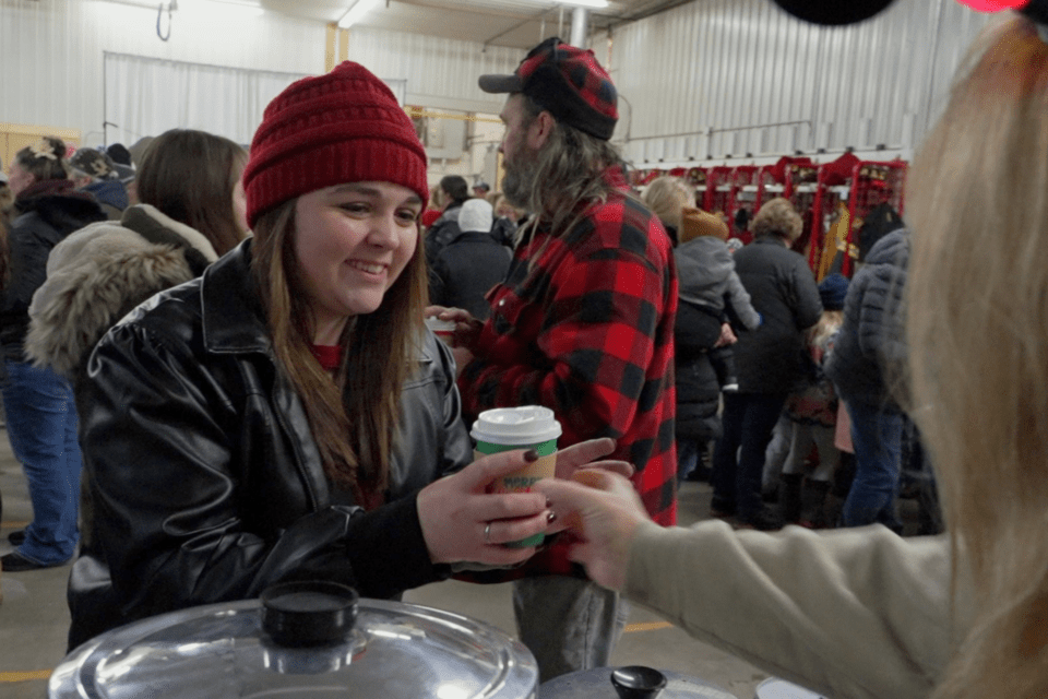 Volunteer passing out cups of hot cocoa