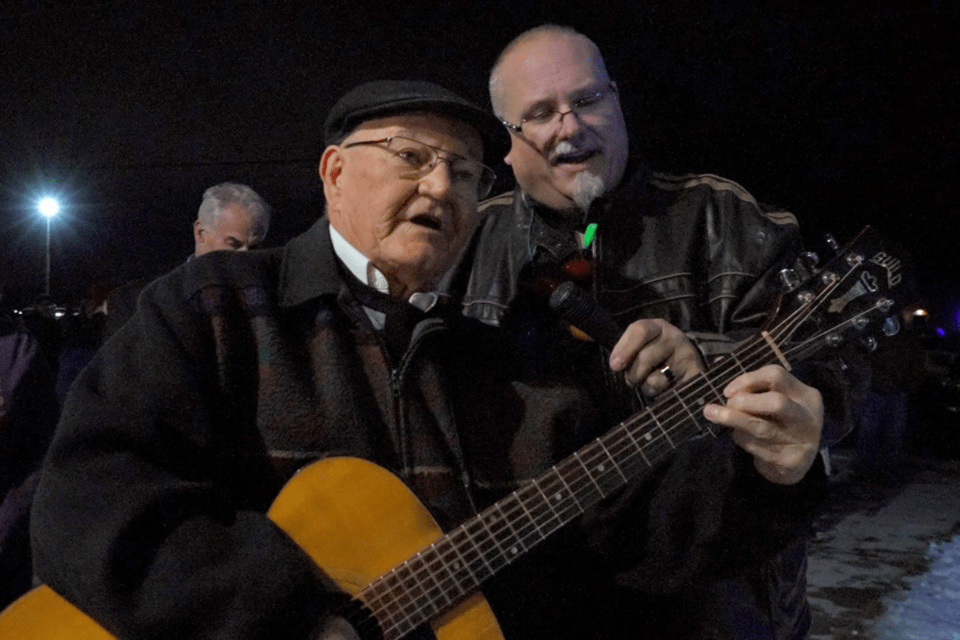 Two men singing Christmas carols