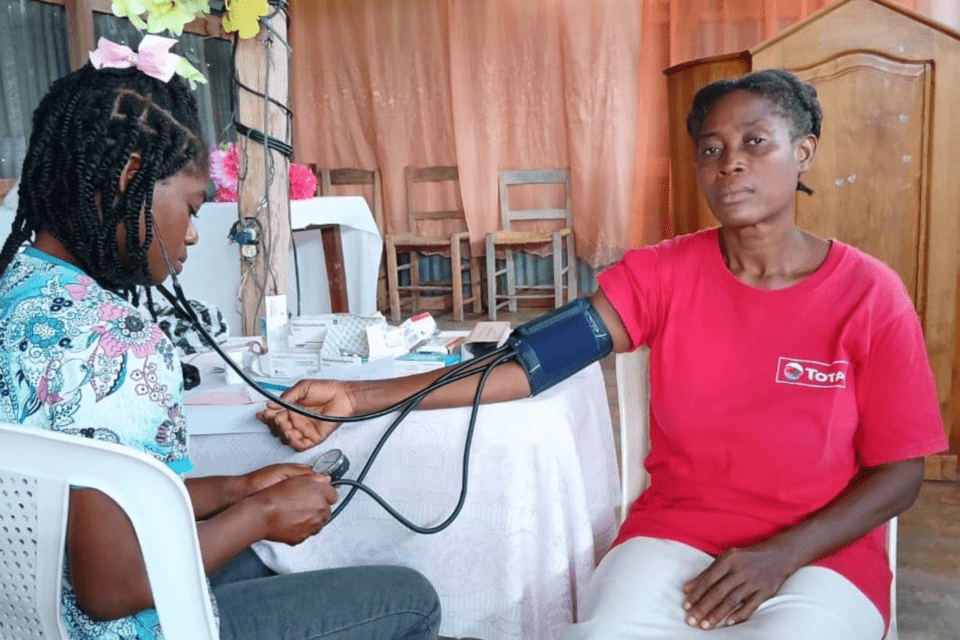 A medical professional takes a woman's blood pressure