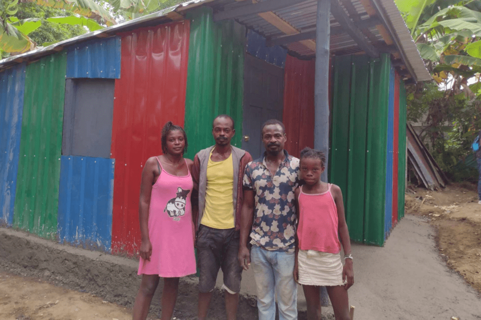 A family receives a shelter home built for them in Haiti