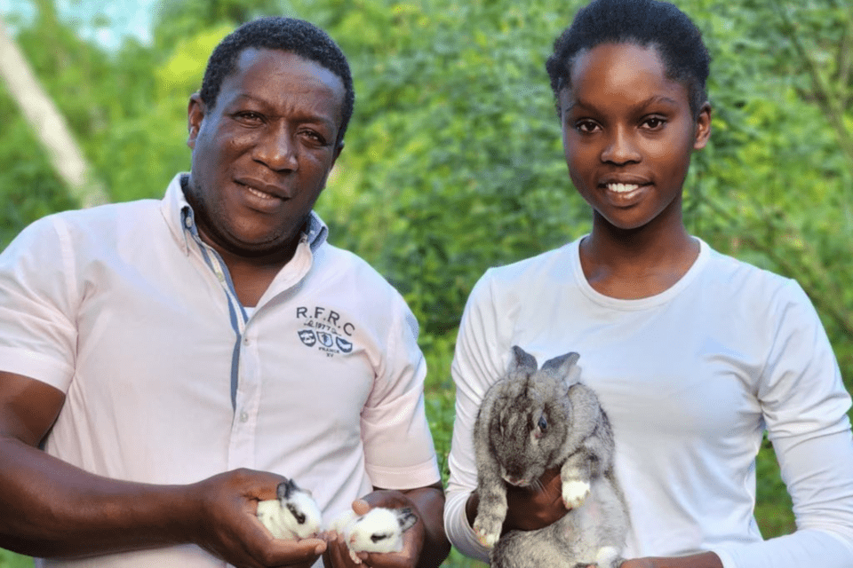 Two people holding rabbits