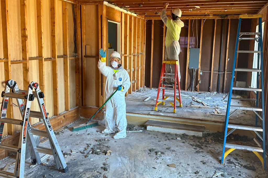 Volunteers removing insulation following hurricane damage