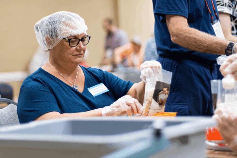 Woman packing a meal kit for global hunger relief