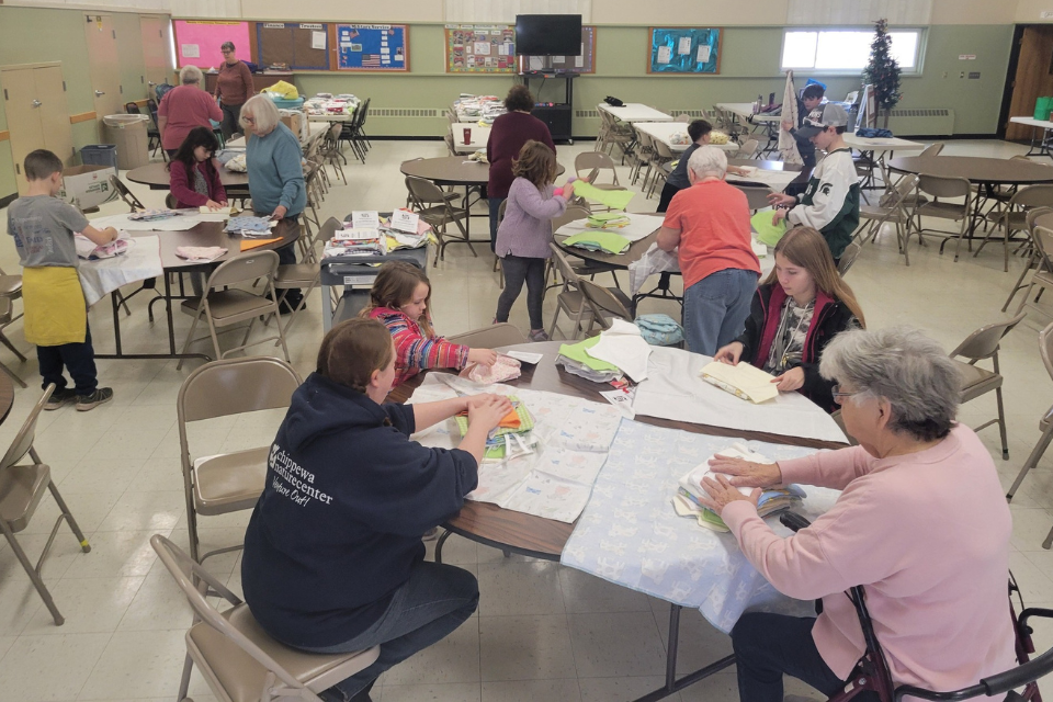 Youth and adults assembling layette kits
