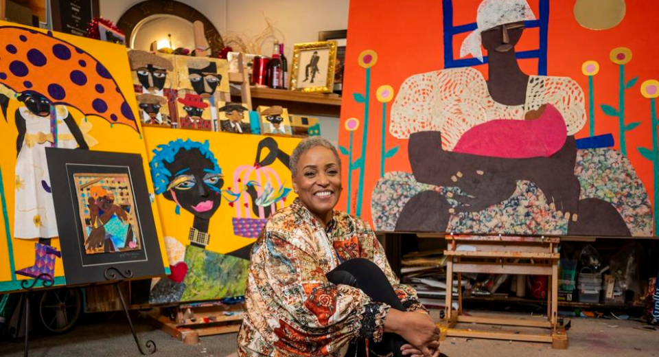 Black artist Judy Bowman surrounded by her artwork