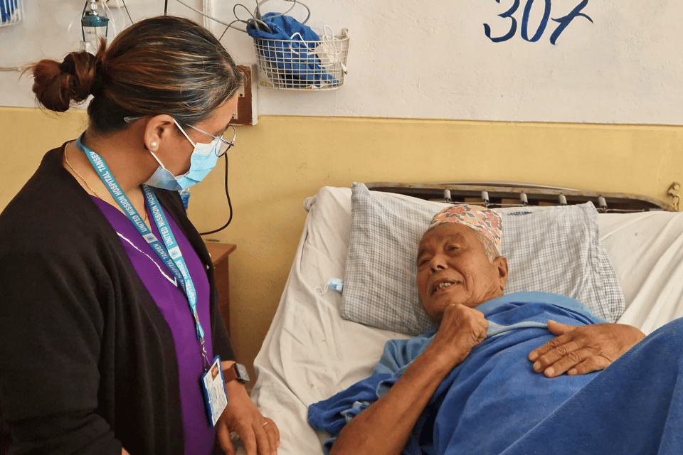Pastoral care staff member visits patient in hospital