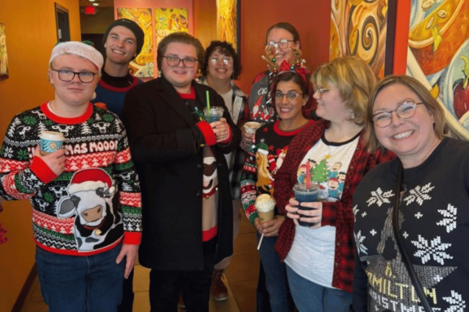 People dressed in Christmas sweaters