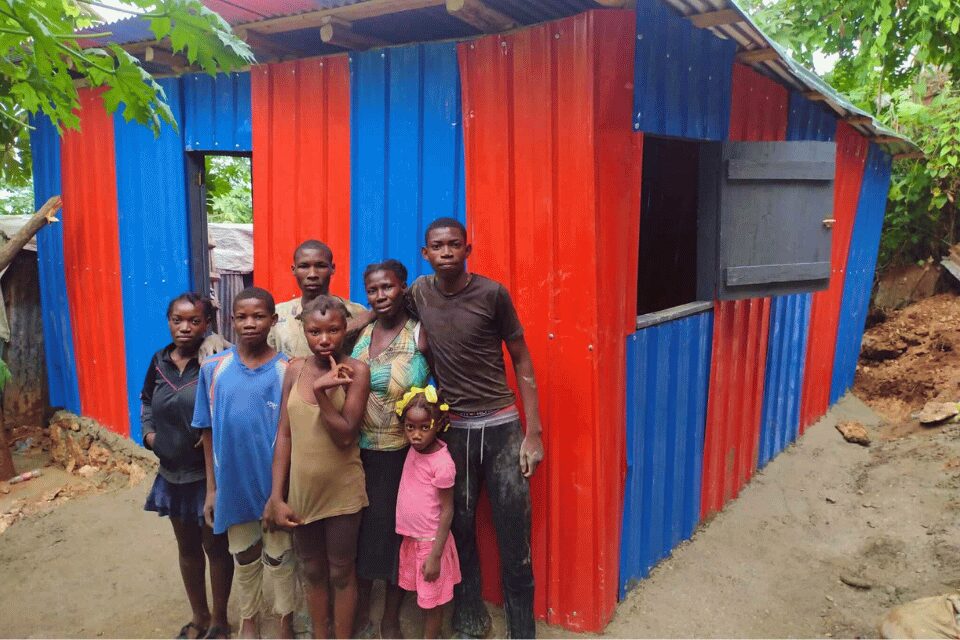 Family in front of their new home in Haiti