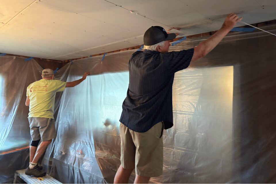 Two men repairing a celing