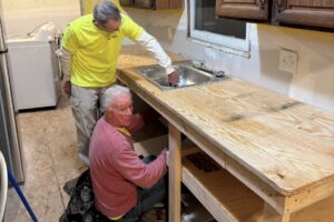 Two men replacing a sink