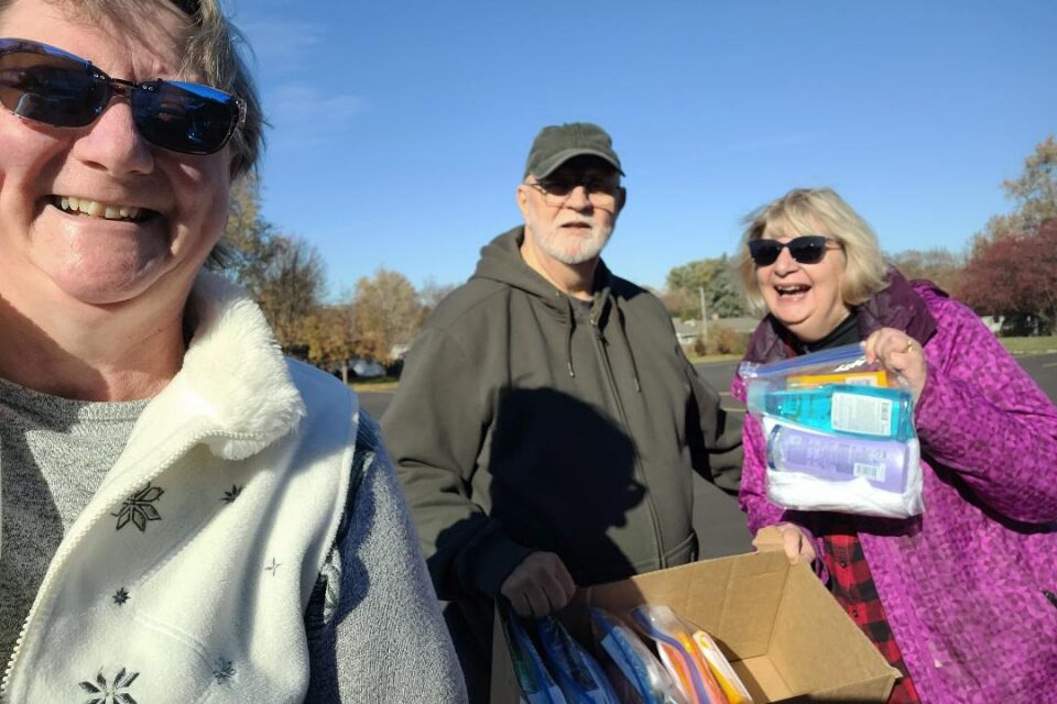 Three people delivering disaster kits