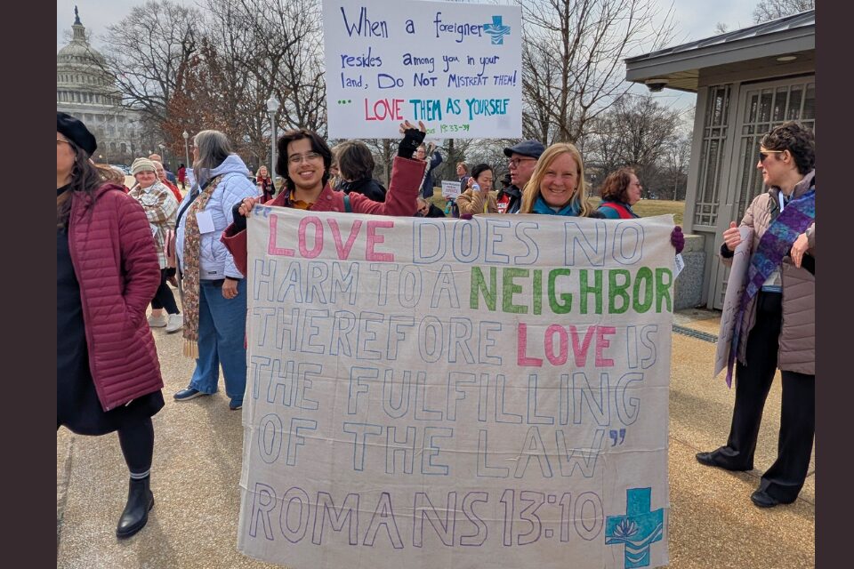 Young people of faith holding a sign at a rally