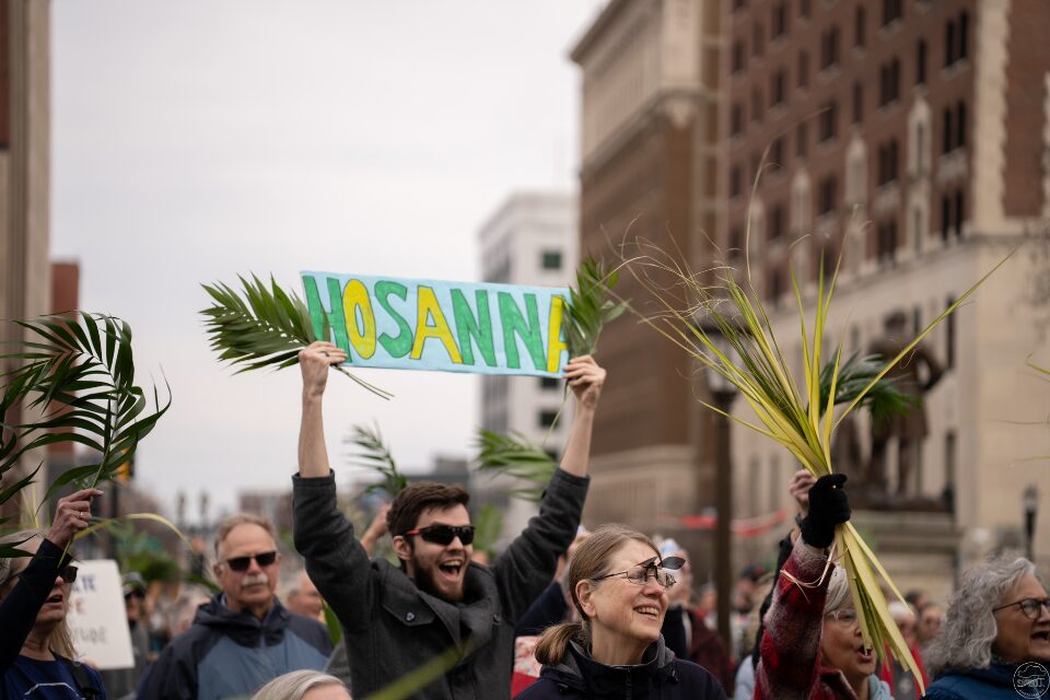 Marchers holding signs that proclaim hosanna