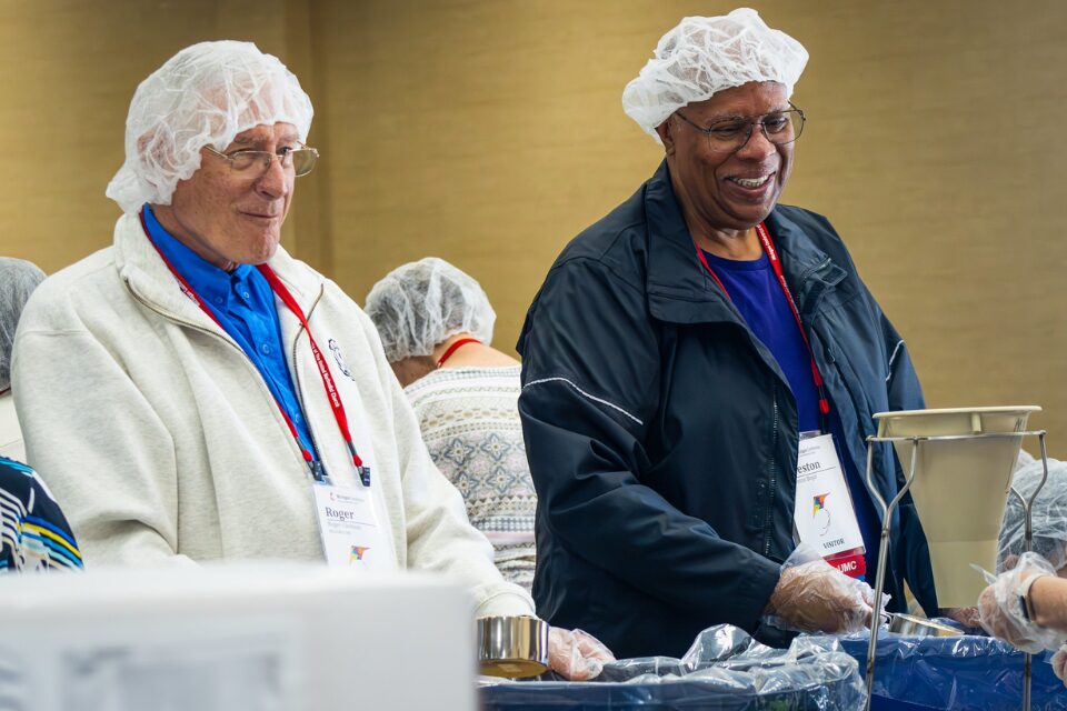 Two men packing meal kits for hunger relief