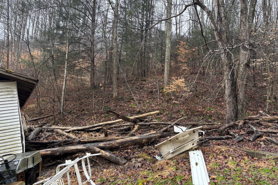 Logging debris piled up against a house