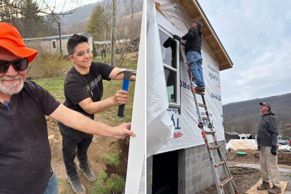 Volunteers putting up siding on a house