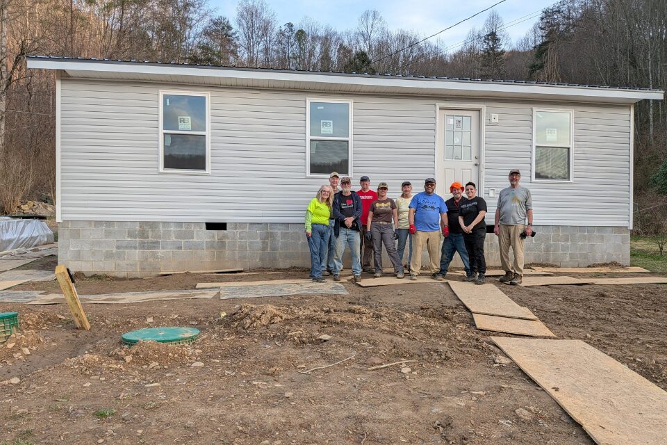 Team in front of a house rebuild