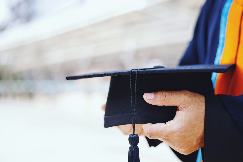 Person holding a graduation cap