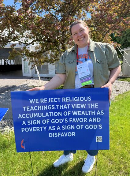 Woman standing next to a sign