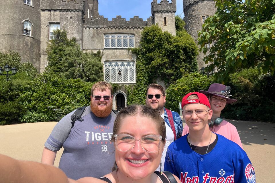 Youth and young adults standing in front of a castle
