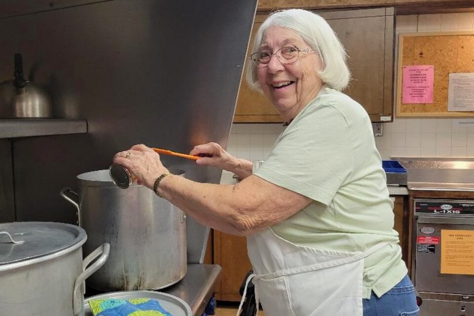 Woman making soup at a stove