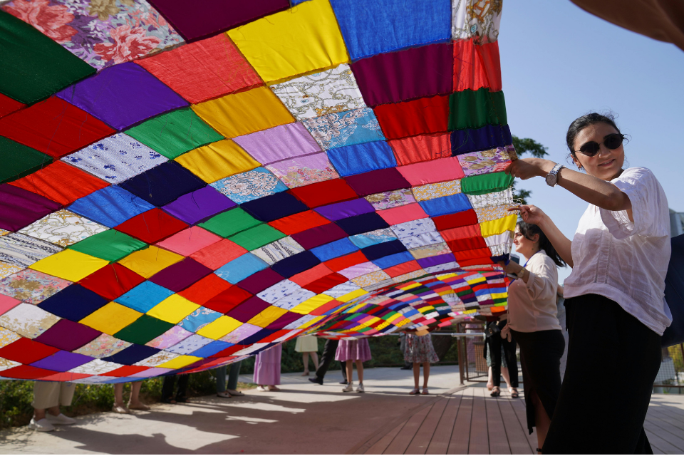 Women holding a patchwork quilt