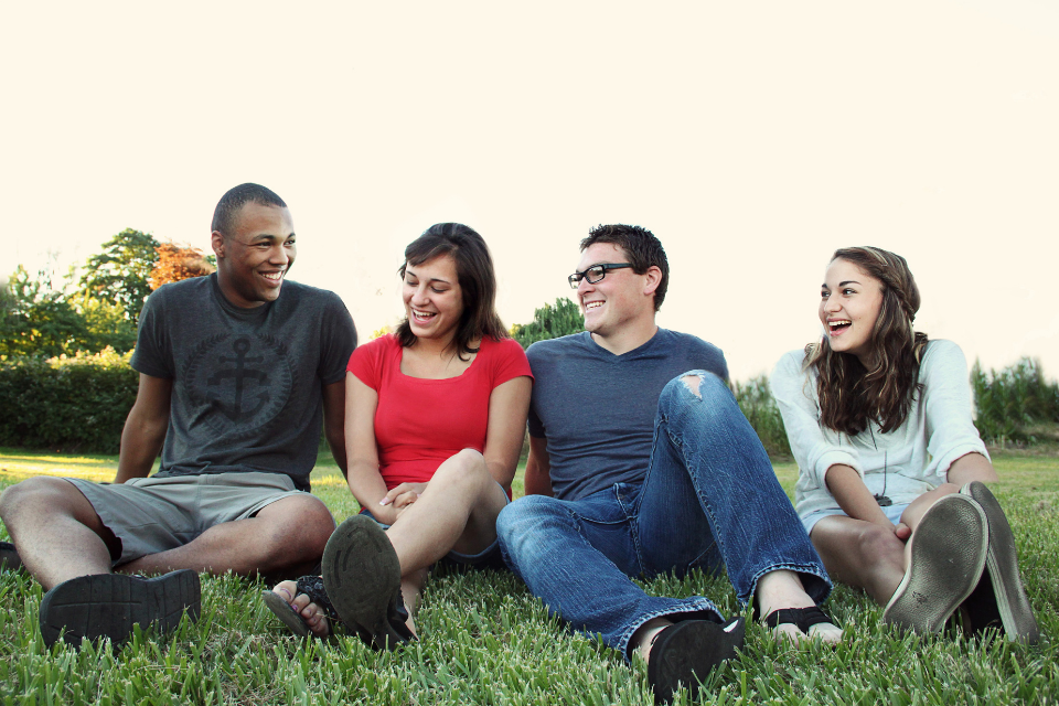 Young adults sitting in grass