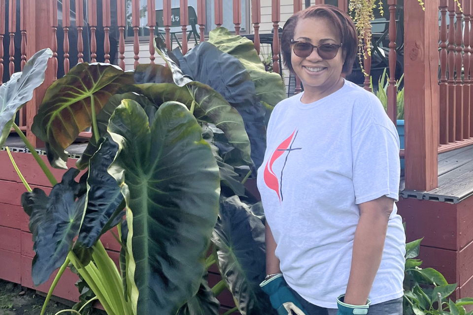 Woman standing next to big plant